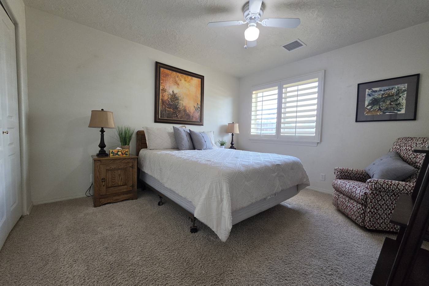 Guest bedroom — queen bed and plantation shutters
